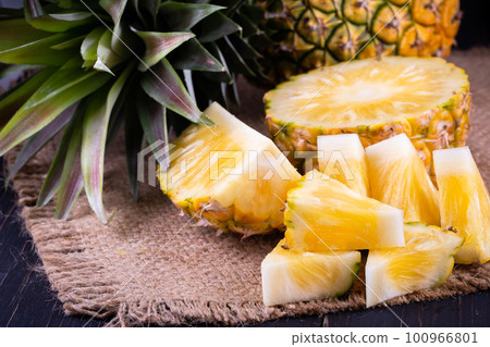 Fresh pineapple on black wood, black background. 100966801