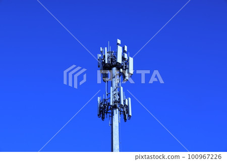 Telecommunications company's base station tower standing in the clear blue sky Telecommunications company's base station tower standing in the clear blue sky 100967226