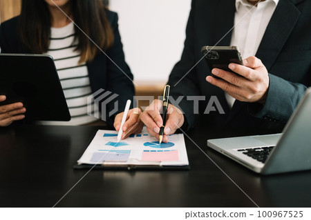 Team business meeting presentation. Hand businessman working project in modern office.Laptop computer and tablet and smart phone on white desk in morning light Team business meeting presentation. Hand businessman working project in modern office.Laptop computer and tablet and smart phone on white desk in morning light 100967525