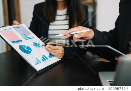 Team business meeting presentation. Hand businessman working project in modern office.Laptop computer and tablet and smart phone on white desk in morning light 100967534