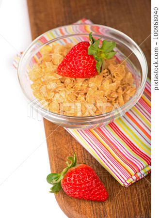Yogurt bowl with fresh sliced strawberries and dry corn flakes. Traditional corn flakes breakfast concept. Healthy eating concept. Food and health Yogurt bowl with fresh sliced strawberries and dry corn flakes. Traditional corn flakes breakfast concept. Healthy eating concept. Food and health 100968040