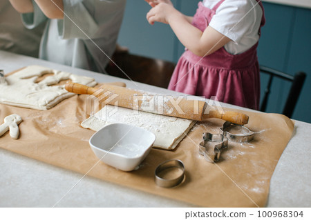 Family time. Mother and children are preparing Easter cookies. Family time. Mother and children are preparing Easter cookies. 100968304