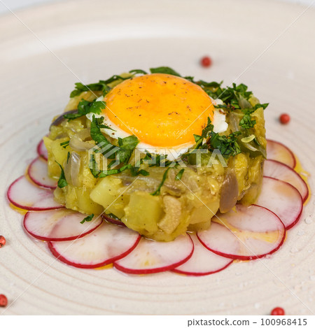 Recipe of courgette meat, onion, potato, garlic, pepper, coriander and egg yolk fried on a bed of 100968415