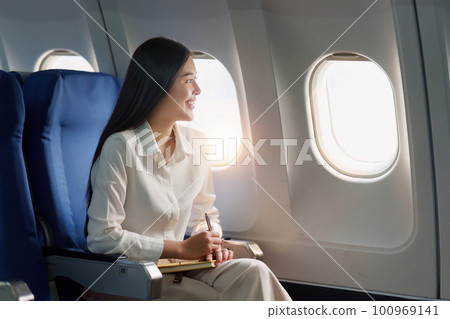 Beautiful Asian businesswoman working with laptop in aeroplane. working, travel, business concept Beautiful Asian businesswoman working with laptop in aeroplane. working, travel, business concept 100969141