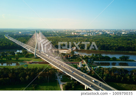 Aerial drone view of Redzinski bridge over Odra river in Wroclaw city, Poland. Large cable stayed bridge with car traffic in european city, bird eye view. Transportation infrastructure and logistic 100970035