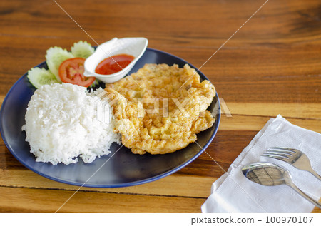 Omelet rice on wooden table, Thai Breakfast Omelet rice on wooden table, Thai Breakfast 100970107