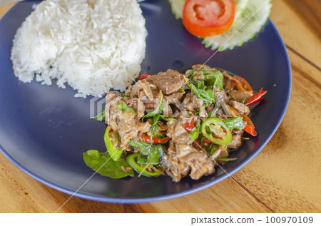 Stir Fried Basil with Stewed Pork on Rice popular thai food with wooden table background. side view 100970109