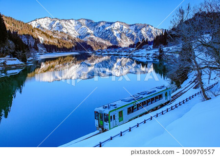 Taishi village early in winter and Kiha 110 series Tadami Line train (Kanayama Town, Fukushima Prefecture, February) 100970557