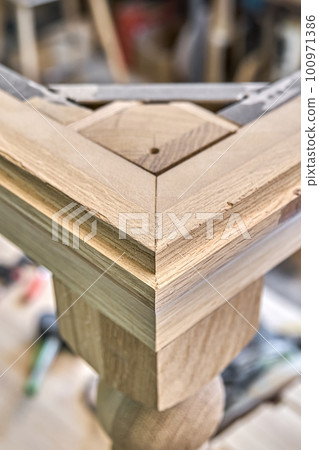 Wooden dining table with carved leg of solid oak and metal frame build process in workshop close up view Wooden dining table with carved leg of solid oak and metal frame build process in workshop close up view 100971386