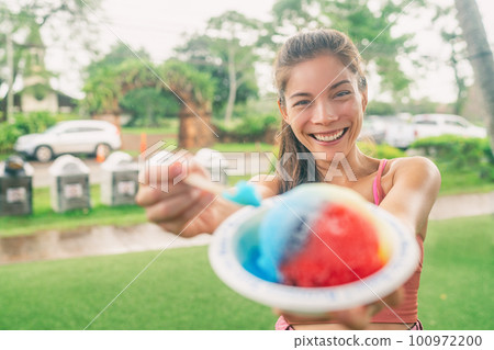 Shave Ice Hawaii Asian woman tourist eating local food hawaiian snow cone dessert food happy showing colorful ice cream treat. 100972200