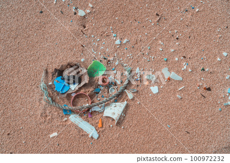 Plastic pollution on shore of beach. Ocean microplastic marine debris. 100972232