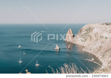 Aerial view from above on calm azure sea and volcanic rocky shores. Small waves on water surface in motion blur. Nature summer ocean sea beach background. Nobody. Holiday, vacation and travel concept Aerial view from above on calm azure sea and volcanic rocky shores. Small waves on water surface in motion blur. Nature summer ocean sea beach background. Nobody. Holiday, vacation and travel concept 100974063
