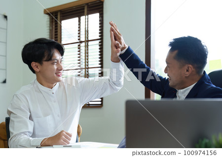 Portrait of two young Asian entrepreneurs congratulating them with smiling faces after successful investment negotiations. Portrait of two young Asian entrepreneurs congratulating them with smiling faces after successful investment negotiations. 100974156