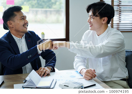 Portrait of two young Asian entrepreneurs congratulating them with smiling faces after successful investment negotiations. 100974195