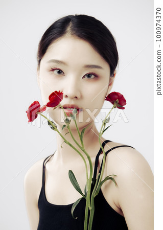 Beautiful girl with a bouquet of red persian buttercup flowers 100974370