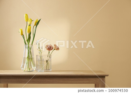 A cozy home with sunlight shining through the windows and fresh flowers 100974530