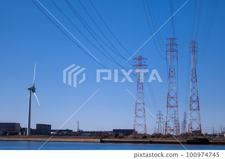 Three power transmission towers and wind turbines in the blue sky, carbon neutral image 100974745