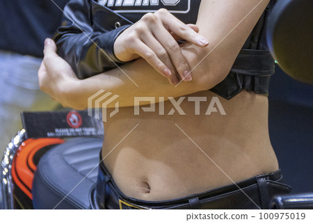 sexy navel showing woman with her arms folded in front of her chest 100975019