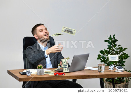 young bearded businessman working on laptop and throwing money 100975081