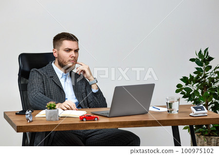 man sitting on chair at table and resting, using laptop 100975102