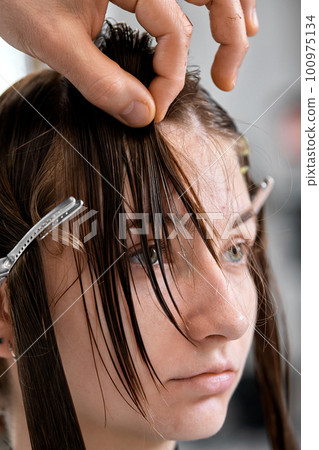 Professional male hairdresser cutting female hair Professional male hairdresser cutting female hair 100975134