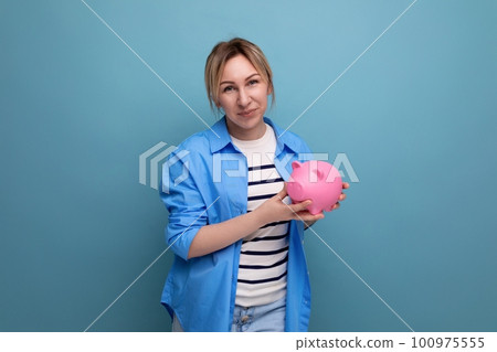 horizontal photo of attractive young woman in casual outfit cute hugging a piggy bank of coins on a horizontal photo of attractive young woman in casual outfit cute hugging a piggy bank of coins on a 100975555