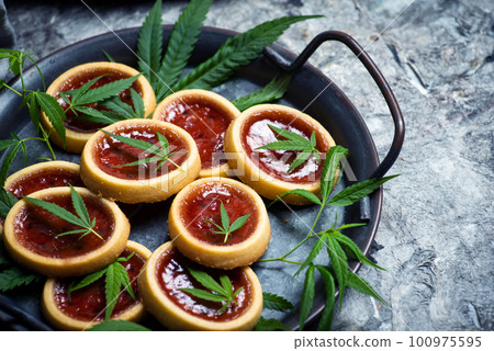 Biscuit with strawberry jam and marijuana leaf 100975595