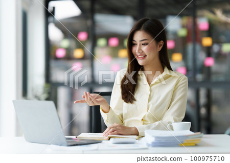 Beautiful Asian Banker or Accountant makes financial report and tax, analyzes profits. Accountant checks status of financial 100975710