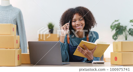 American African entrepreneur smile and checking online order. Successful SME entrepreneur concept American African entrepreneur smile and checking online order. Successful SME entrepreneur concept 100975741