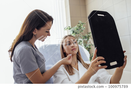 Doctor checking woman face skin in cosmetology clinic before plastic surgery 100975789