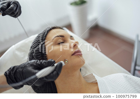 Beautiful caucasian young woman is doing a mole removal procedure in a modern beauty cosmetic dermatological clinic 100975799