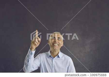 Happy senior man has idea or presents incredible proposal by pointing his finger at copy space. Happy senior man has idea or presents incredible proposal by pointing his finger at copy space. 100975888