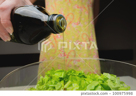 healthy eating, vegetarian food, dieting and people concept - close up of young woman dressing vegetable salad with olive oil at home healthy eating, vegetarian food, dieting and people concept - close up of young woman dressing vegetable salad with olive oil at home 100975998