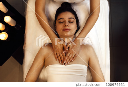 Close up portrait of a young beautiful woman getting facial massage 100976631