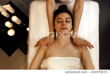 Close up portrait of a young beautiful woman getting facial massage 100976633