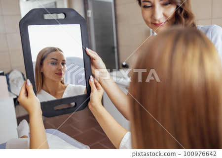 Doctor checking woman face skin in cosmetology clinic before plastic surgery 100976642