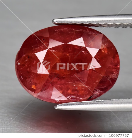 Natural gemstone orange Padparadscha sapphire on gray background Natural gemstone orange Padparadscha sapphire on gray background 100977767