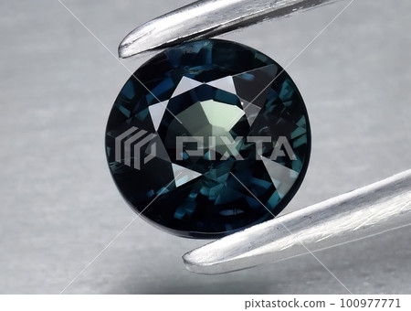 Natural gemstone blue sapphire on gray background 100977771
