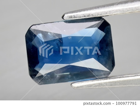 Natural gemstone blue sapphire on gray background Natural gemstone blue sapphire on gray background 100977791