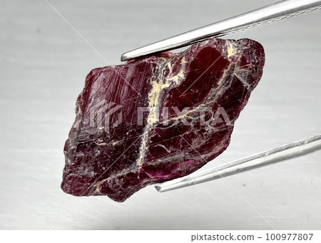 Natural gemstone red ruby on gray background 100977807
