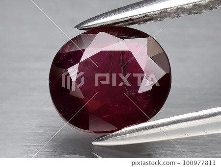 Natural gemstone red ruby on gray background 100977811
