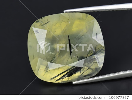 Natural gemstone green prehnite on gray background 100977827