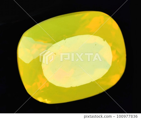 Natural gemstone yellow neon opal on black background 100977836