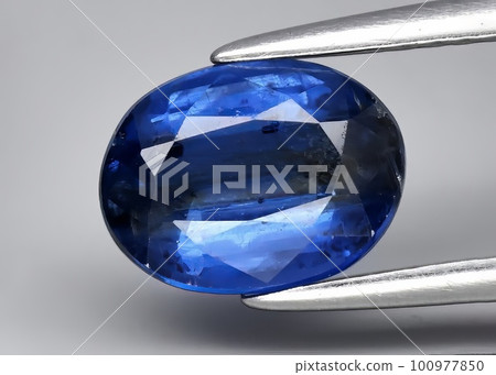 Natural gemstone blue kyanite on gray background Natural gemstone blue kyanite on gray background 100977850