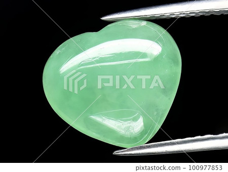 Natural gemstone green jade on gray background Natural gemstone green jade on gray background 100977853