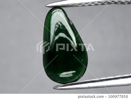 Natural gemstone green jade on gray background Natural gemstone green jade on gray background 100977858