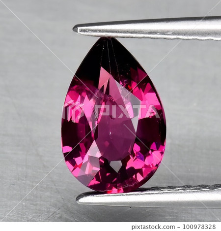 Natural gem red rhodolite garnet on gray background Natural gem red rhodolite garnet on gray background 100978328