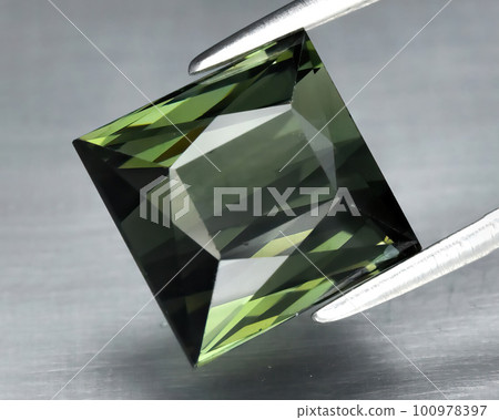 Natural gem green tourmaline on gray background 100978397