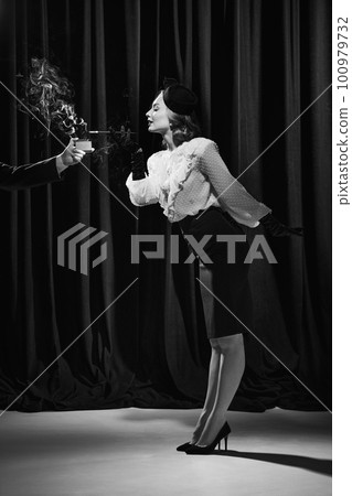 Portrait of one beautiful woman wearing costume standing and smoking. Monochrome Portrait of one beautiful woman wearing costume standing and smoking. Monochrome 100979732