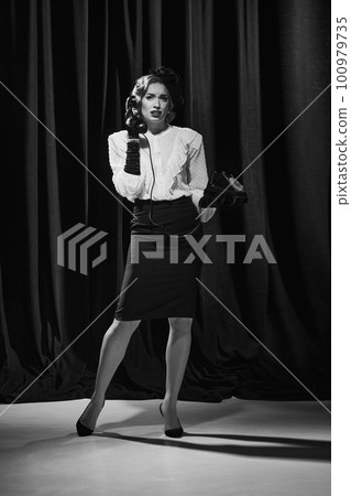 One pretty wearing old costume woman talking on phone with dislike facial expression. Monochrome, black and white 100979735